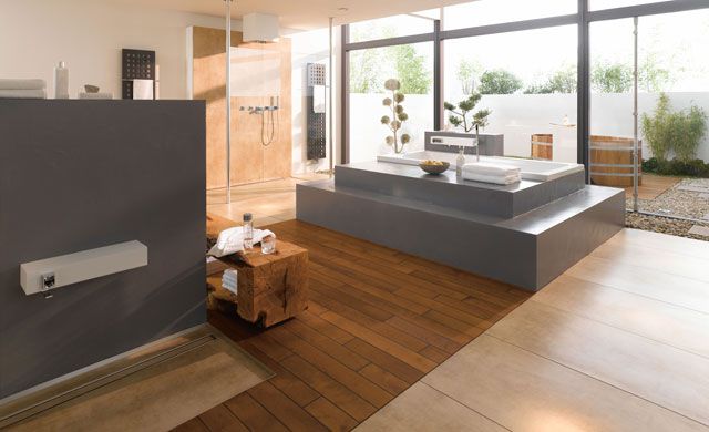 Modernes Badezimmer mit Fliesen der Serie Bosco von Agrob Buchtal in Holzoptik, freistehender Badewanne und Dekoration.